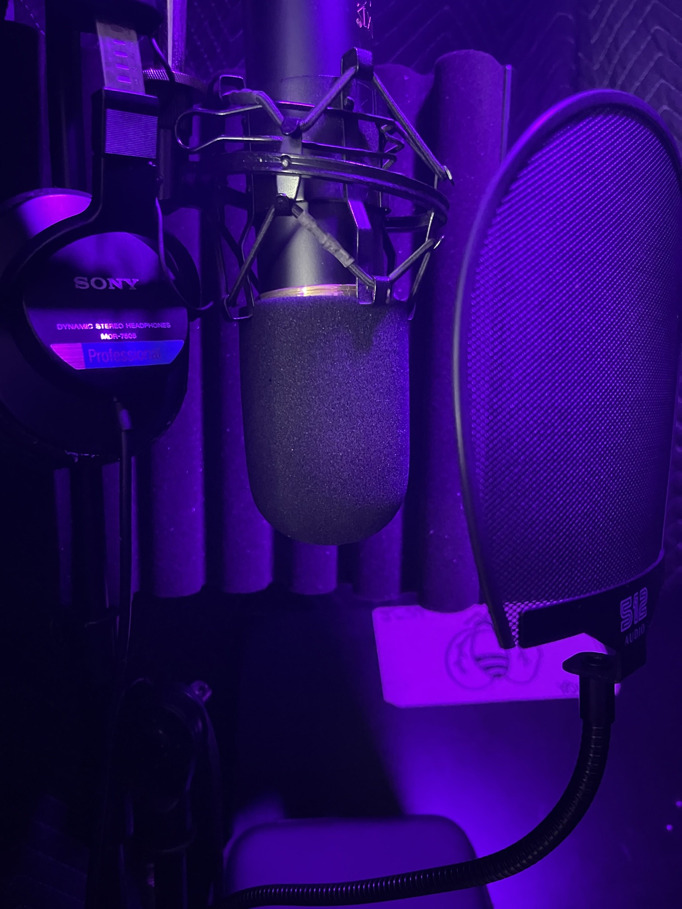 Microphone, reflection filter, and headphones in the Rocsoulfully Studios vocal booth